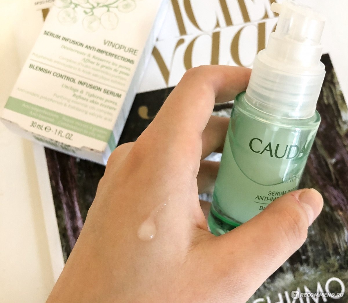 Caudalie Vinopure сыворотка — зелёный флакон с белой крышкой в руке, сыворотка с салициловой кислотой для проблемной кожи