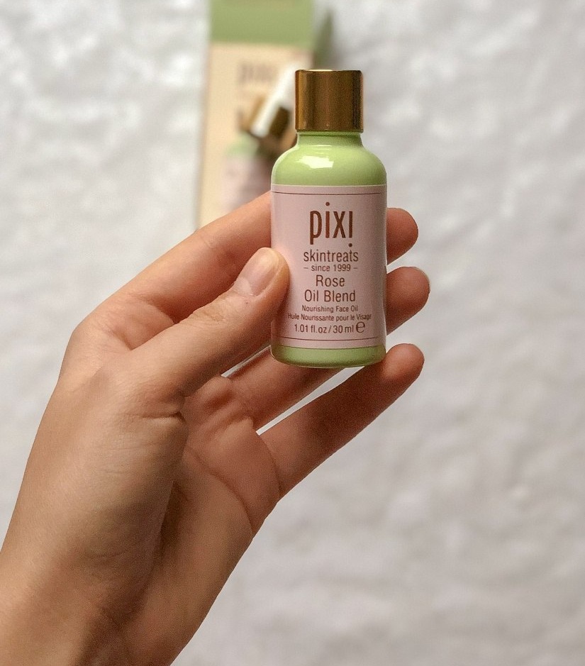 Pixi Rose Oil Blend — прозрачная бутылочка с розовым маслом для лица в руке, аромат розы, лёгкое питание без ощущения плёнки