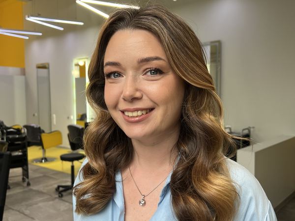 Улыбающаяся девушка с каштановыми волосами, уложенными крупными волнами — макияж с выездом